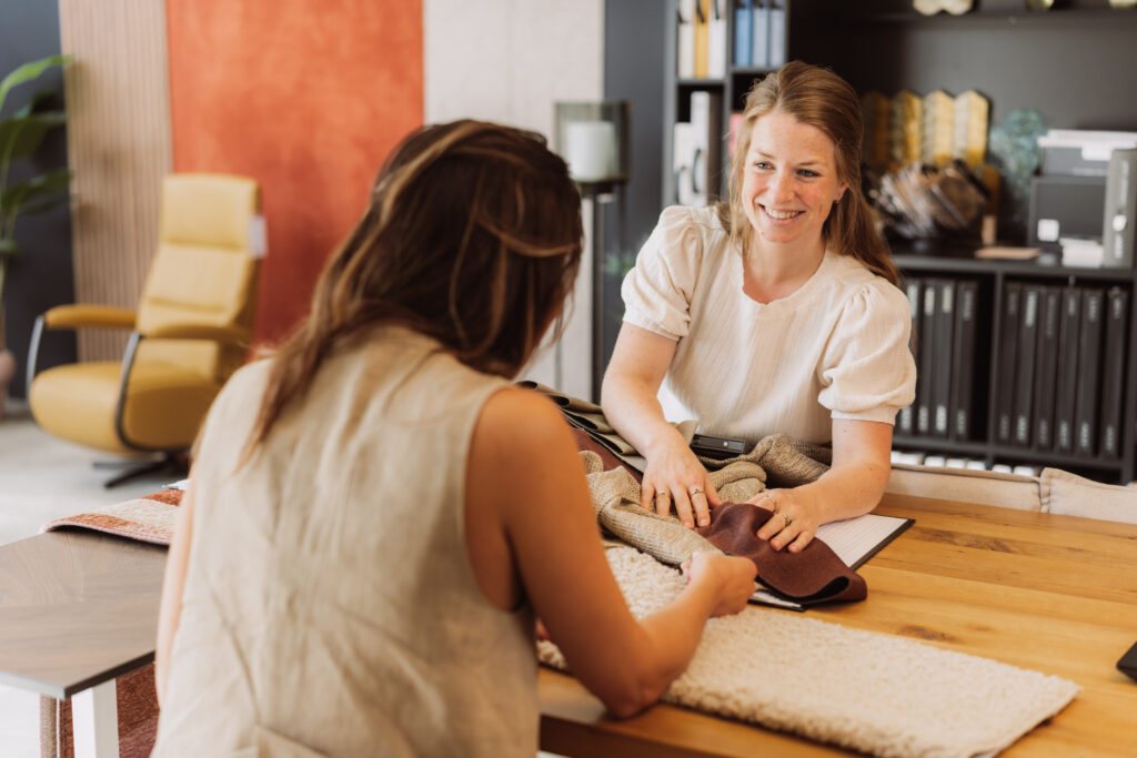 Een adviseur van Seiger bespreekt stoffen met een klant aan tafel