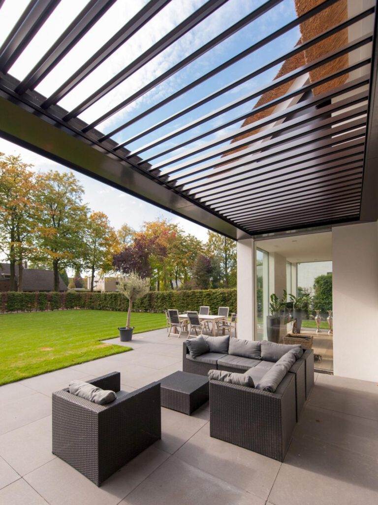 Overkapping met loungeset en uitzicht op de tuin